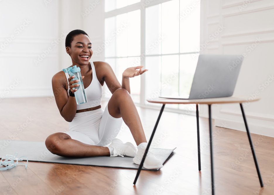 A girl communicating thru a computer while working out illustrating online coaching.